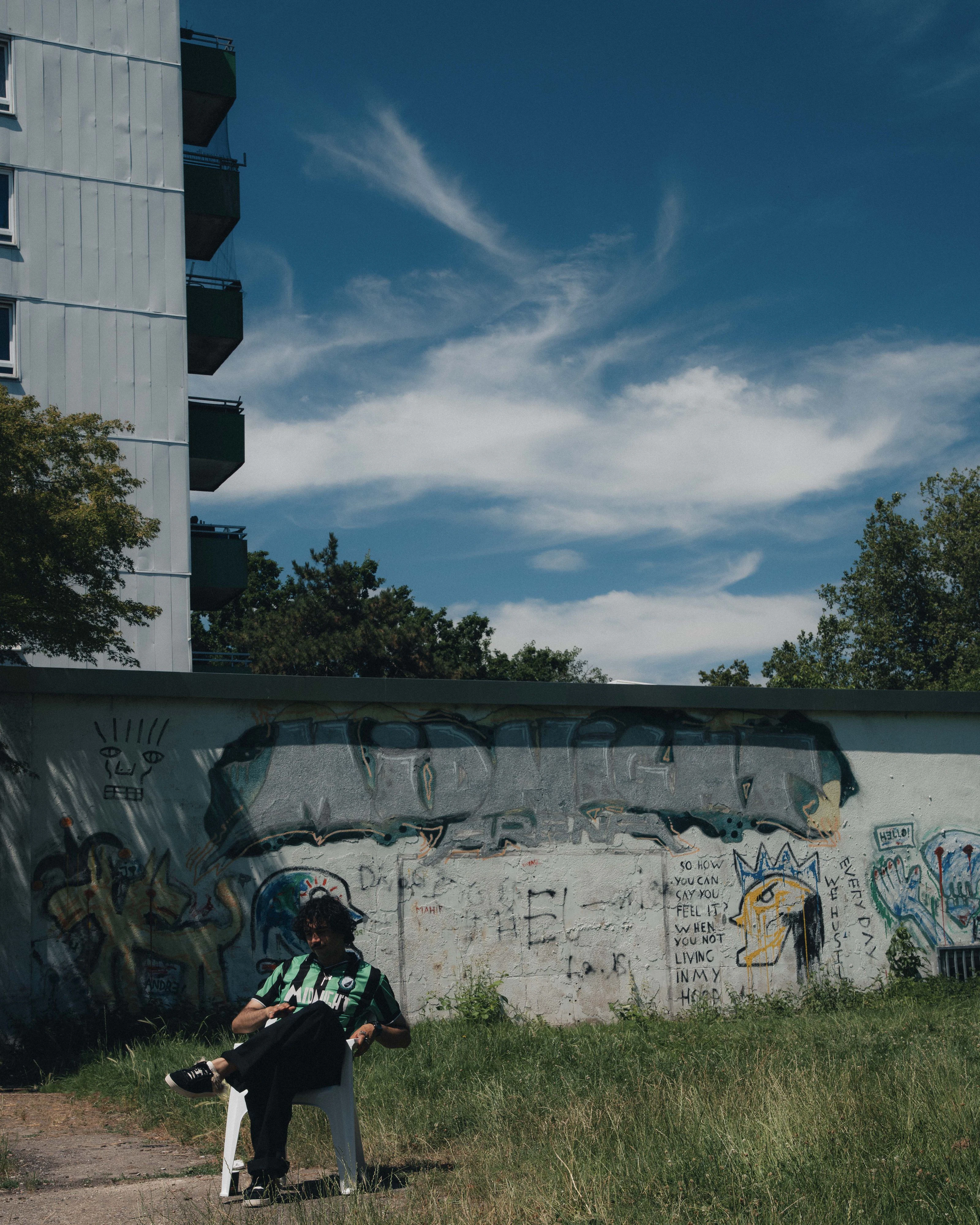 Can Demirezen vor dem Graffiti, das er vor Jahren an eine Wand in der Mönchengladbacher Hochhaussiedlung gesprüht hat.