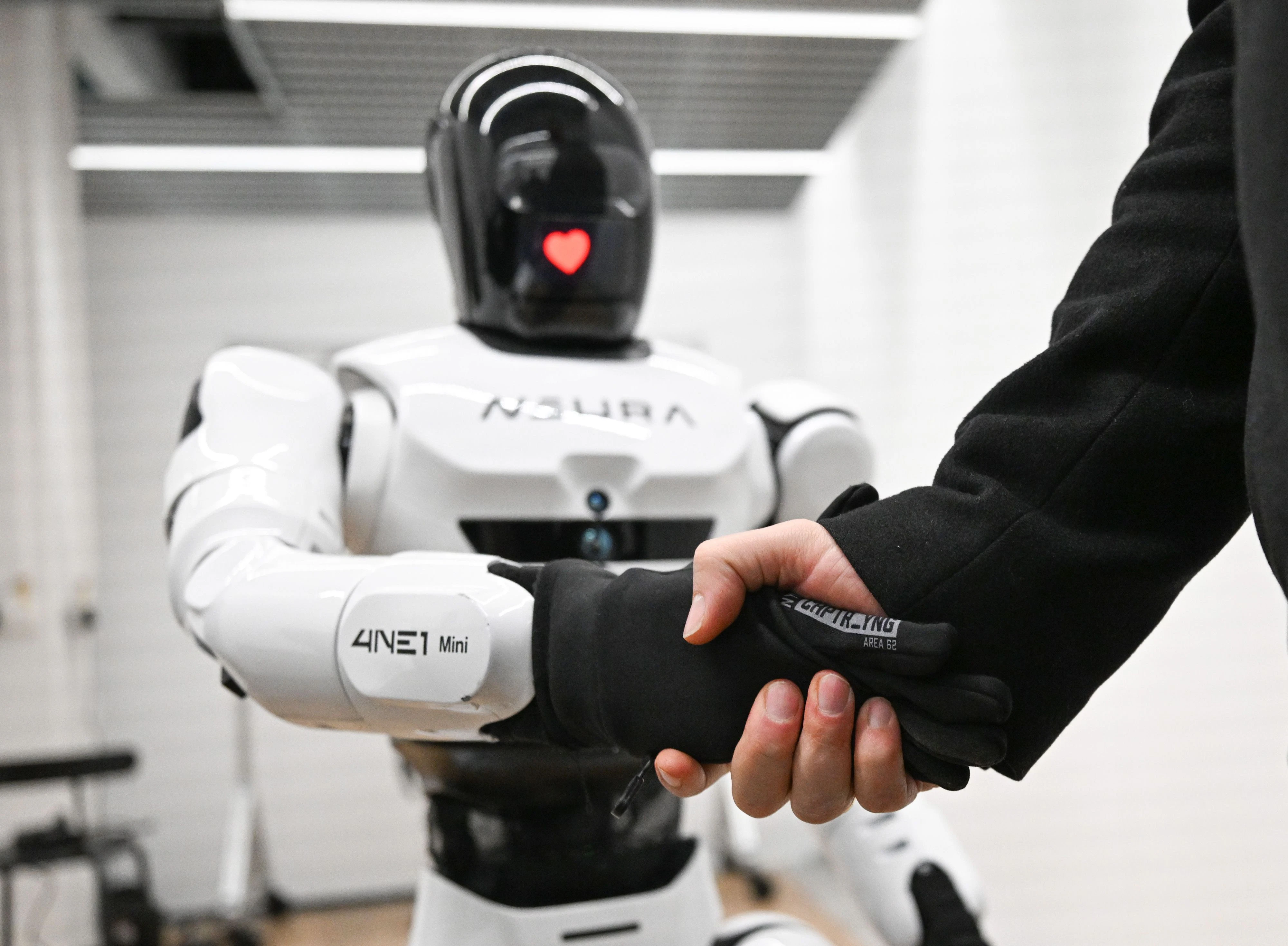 David Reger gibt einem humanoiden Roboter die Hand. Solche Maschinen werden immer mehr physische Arbeiten erledigen, erwartet der Gründer.